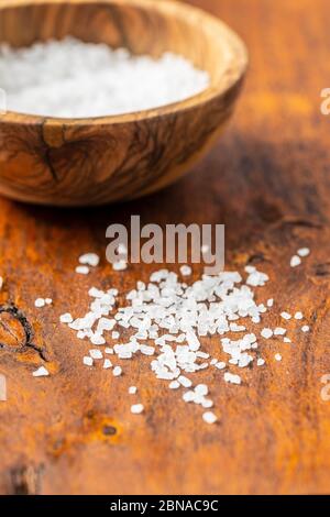 Sel blanc à grain grossier sur table en bois. Banque D'Images