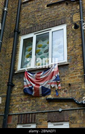 LONDRES, ROYAUME-UNI - 14 janvier 2020 : un drapeau britannique de l'Union Jack décrété est attaché à une fenêtre avec rideau d'un Council House à l'est de Londres, au Royaume-Uni. Banque D'Images