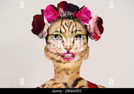 Photo créative d'une femme avec un masque de tigre et fleurs dans un studio isolé sur fond blanc Banque D'Images
