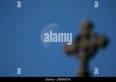 WIMBLEDON LONDRES, 14 mai 2020. ROYAUME-UNI. Une croix d'église devant une lune de gibbures à l'aube au-dessus de Wimbledon SW London. Crédit : amer ghazzal/Alay Live News Banque D'Images