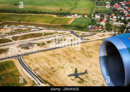 Vue sur le village, les champs agricoles depuis un avion près de Bratislava, Slovaquie. Ombre d'un avion sur le terrain. Banque D'Images