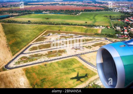 Vue sur le village, les champs agricoles depuis un avion près de Bratislava, Slovaquie. Ombre d'un avion sur le terrain. Banque D'Images