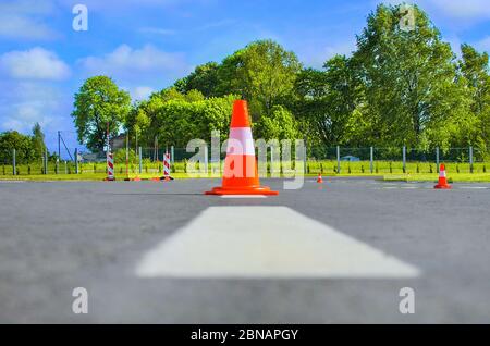 Cône de circulation sur asphalte foncé. Cône en caoutchouc rouge pour la construction de routes. Travaux routiers, aire de stationnement.cône de circulation sur la piste d'aéroport. Clôture de cône p Banque D'Images