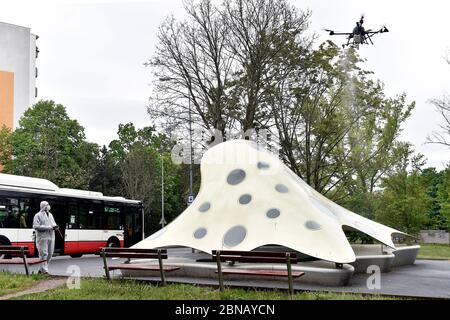 Brno, République tchèque. 14 mai 2020. L'équipage de la société spécialisée de nettoyage, à l'aide d'un drone, désinfecte l'arrêt de bus des transports publics Loosova, sous forme de miniature de la proposition de Jan Kaplicky pour le bâtiment de la Bibliothèque nationale à Prague, dans le district de Brno à Lesna, République tchèque, le 14 mai 2020. Crédit: Vaclav Salek/CTK photo/Alay Live News Banque D'Images