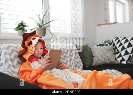 Belle jeune fille avec costume de lion joue avec un téléphone mobile ou une tablette Banque D'Images