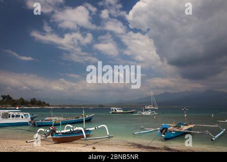 Vue horizontale de certains bateaux de pêche indonésiens traditionnels en outrigger s'agrippent sur la plage, Gili Air, îles Gili, Indonésie Banque D'Images