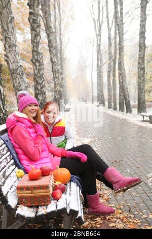 deux jeunes filles assises sur un banc recouvert de neige Banque D'Images