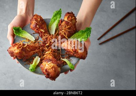 Gai Tod Hat Yai ou Thai Deep Fried Chicken sur plaque grise sur fond de béton. Gai Tod Hed Yai est un plat de cuisine de thaïlande. Cuisine thaïlandaise. Poulet frit le Banque D'Images