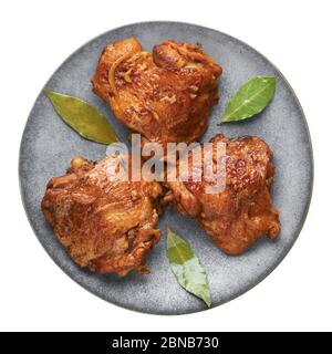 Adobo de poulet philippin sur plaque grise isolée sur fond blanc. L'adobo de poulet est un plat de cuisine philippin de cuisses de poulet braisées, sauce soja, vinaigre, Banque D'Images