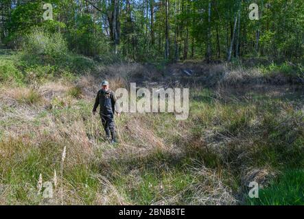 Langenherbau, Allemagne. 06e mai 2020. Ulf Bollack, garde-forestier de la région de Brandebourg, se dresse dans un étang asséché de la zone européenne de protection Höllenberge au sud de Luckau dans le district de Dahme-Spreewald. Les 16 espèces d'amphibiens de Brandebourg souffrent de la sécheresse. La garde de la nature, qui s'occupe des barrières de crapaud et recueille des données pendant la surveillance, a obtenu des résultats alarmants. Les mesures de protection ne fonctionnent qu'avec l'agriculture. Credit: Patrick Pleul/dpa-Zentralbild/ZB/dpa/Alay Live News Banque D'Images