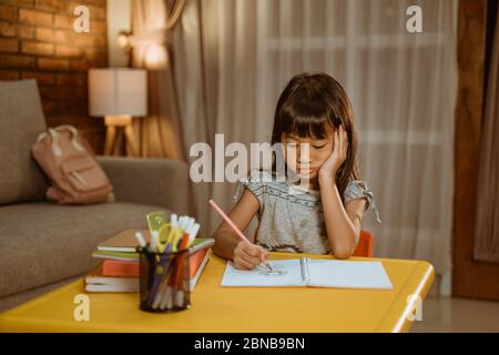 portrait d'un enfant sérieux étudiant à la maison par lui-même Banque D'Images