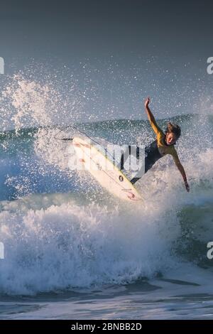 Action sauvage spectaculaire alors qu'un jeune surfeur se balade sur une vague sauvage à Fistral à Newquay, en Cornouailles. Banque D'Images