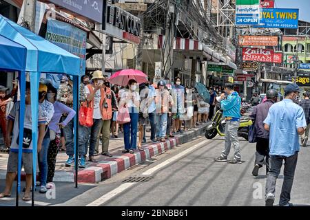 Covid-19 et coronavirus ont un effet sur le revenu. Les gens font la queue pour des dons de nourriture gratuits donnés par les entreprises locales à Pattaya Thaïlande Asie du Sud-est Banque D'Images