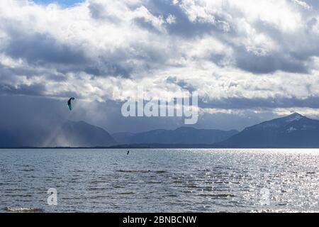 Kite-surfeur dans une tempête de printemps sur le lac Chiemsee en face de paysage de montagne, Allemagne, Bavière, lac Chiemsee Banque D'Images