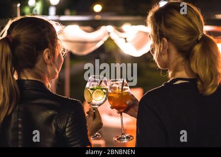 Deux femmes sirotant des cocktails au bar Banque D'Images