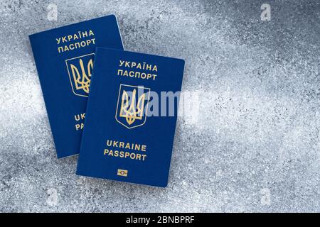 Deux passeports biométriques internationaux de citoyen ukrainien, documents de voyage ukrainiens. Fond gris, emplacement vide, espace de copie Banque D'Images