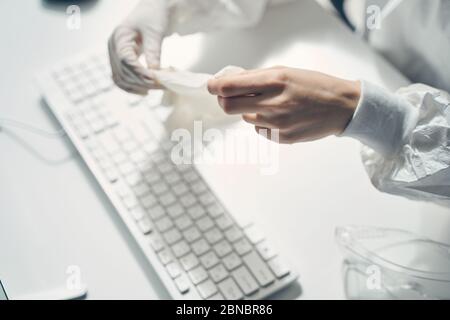 Jeune femme mettant des gants stériles au travail Banque D'Images