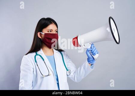 Une femme médecin criant à travers le mégaphone Banque D'Images