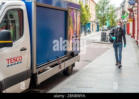 Clonakilty, West Cork, Irlande. 14 mai 2020. Un homme portant un masque pour se protéger de Covid-19 marche devant un camion Tesco Home Delivery à Clonakilty. Crédit : AG News/Alay Live News Banque D'Images