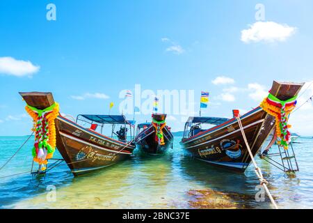 Bateau à queue de logail thaïlandais avec décorations sur l'arc. Bateau amarré au large de la rive sablonneuse. Paysage tropical Banque D'Images