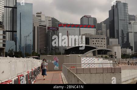 Hong Kong, CHINE. 14 mai 2020. Une femme masquée se promo le long de la promenade du bord de mer à l'extérieur DU CENTRE DES CONGRÈS de WAN Chai, derrière elle, vous verrez un bâtiment avec un écran mobile montrant l'image de plusieurs drapeaux nationaux de la RPC. Hong Kong pro-Beijing les législateurs devraient promouvoir et légiférer la LOI SUR LE DRAPEAU NATIONAL au Conseil législatif de HKSAR le 27 mai-14, 2020 Hong Kong.ZUMA/Liau Chung-ren crédit: Liau Chung-ren/ZUMA Wire/Alay Live News Banque D'Images