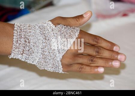 Après le pansement pour les plaies sur la main, homme bandé main, foyer sélectif avec arrière-plan flou. Banque D'Images