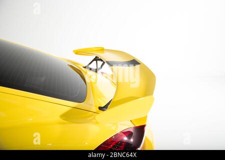 Gros plan d'un aileron sur une voiture jaune moderne les lumières isolées sur un fond blanc Banque D'Images
