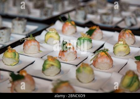 Gros plan de beaucoup de petits pains à sushis en blanc plaques Banque D'Images