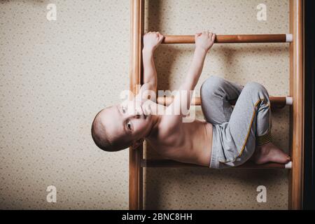 Entraînement à domicile. Le garçon a grimpé le mur d'escalade. Banque D'Images