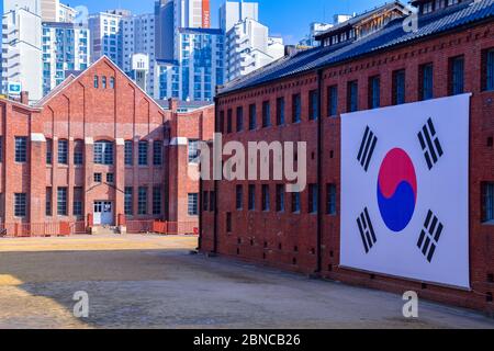 Un grand drapeau coréen accroché devant un bâtiment du Seodaemun prison History Hall, musée et ancienne prison de Seodaemun-gu, Séoul. Banque D'Images