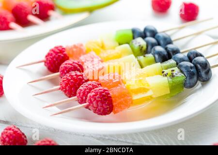 Un kebab de fruits sur une plaque blanche en gros plan. Une nourriture saine et belle Banque D'Images