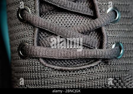 Lacets noirs sur les baskets, trous pour lacets gros plan. Œillets sur les sneakers noires pour homme vue du dessus. Lacets durables en fibres synthétiques. Banque D'Images