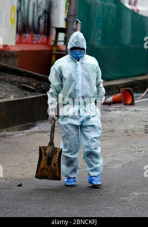 Guwahati, Assam, Inde. 14 mai 2020. Un employé de la municipalité élimine les déchets portant des vêtements protecteurs dans la région de Fancy Bazar, pendant le confinement national en cours de la COVID-19, à Guwahati. L'administration du district de Kamrup (Metro) a déclaré une partie de Fancy Bazaar comme zone de confinement et a également fermé le complexe du marché municipal dans la région après que certaines personnes ont été testées positives avec l'infection à coronavirus. Crédit : David Talukdar/ZUMA Wire/Alay Live News Banque D'Images