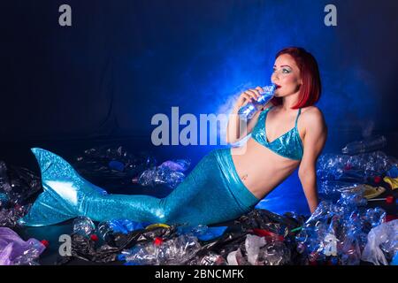 Fantasy stupide sirène dans les profondeurs de l'océan. Pollution des bouteilles et des sacs d'eau en plastique sur le fond marin. Problème environnemental. Banque D'Images