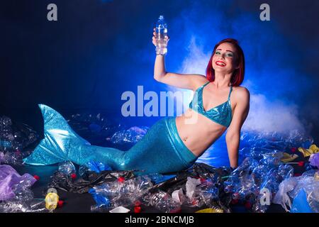 Fantasy stupide sirène dans les profondeurs de l'océan. Pollution des bouteilles et des sacs d'eau en plastique sur le fond marin. Problème environnemental. Banque D'Images