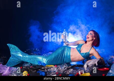 Fantasy stupide sirène dans les profondeurs de l'océan. Pollution des bouteilles et des sacs d'eau en plastique sur le fond marin. Problème environnemental. Banque D'Images