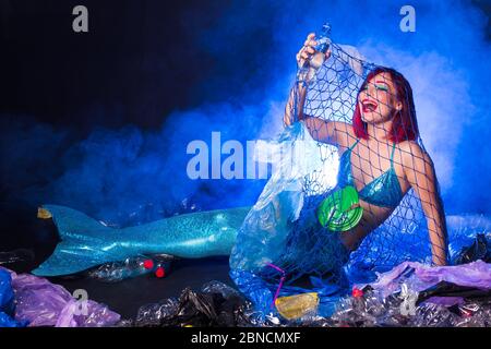 Fantasy stupide sirène dans les profondeurs de l'océan. Pollution des bouteilles et des sacs d'eau en plastique sur le fond marin. Problème environnemental. Banque D'Images