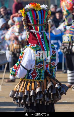 Mummer exécute des rituels avec des costumes, destinés à effrayer les mauvais esprits pendant le festival international de jeux de mascarade Surva. Masques Kuker. Banque D'Images