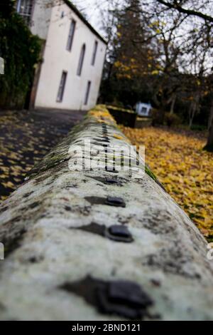 Vue sur un mur entourant une cour d'église en automne Banque D'Images