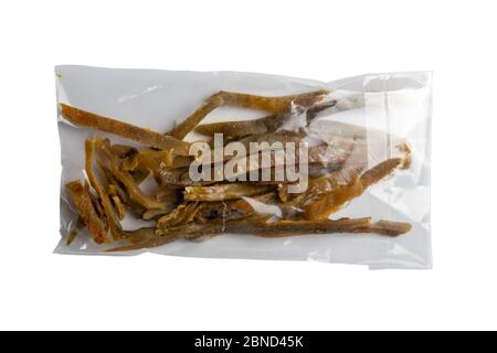 Bâtonnets de poisson à carpe séchés dans un emballage transparent apéritif à la bière isolée sur fond blanc. Snack Fish à la bière. Gros plan Banque D'Images