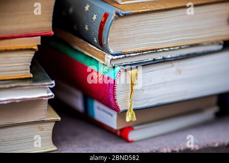 une pile de vieux livres à vendre, un livre avec un signet de tissu jaune Banque D'Images