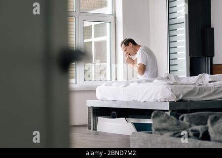 foyer sélectif de toux d'homme malade assis sur le lit à la maison Banque D'Images