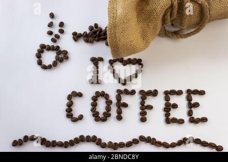 Inscription j'aime le café des grains de café et le sac jute avec le café attaché avec ficelle et les grains de café renversés sur un fond blanc Banque D'Images