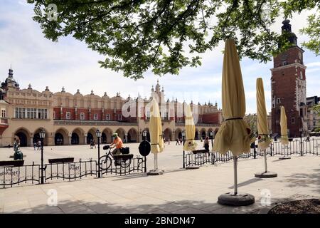Cracovie. Cracovie. Pologne. Place du marché principal déserte. Tour de l'hôtel de ville (Wieza Ratuszowa) et salle de la toile (Sukiennice). Banque D'Images