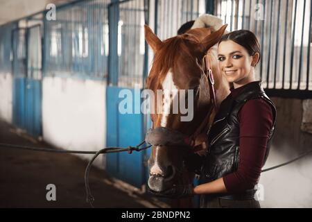 Une jeune femme pilote met une selle de cheval en décrochage Banque D'Images