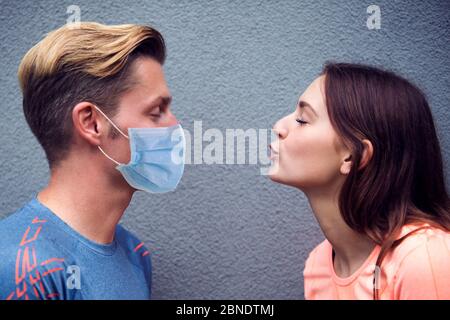 femme essayant d'embrasser un homme avec un masque respiratoire Banque D'Images