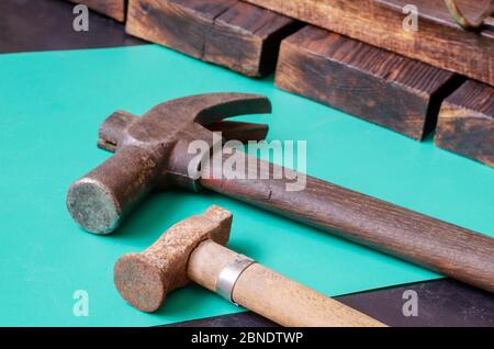 Vieux marteaux rouillés et planches en bois. Deux marteaux vintage aléatoires au premier plan et des planches brossées en arrière-plan. Artisanat, main d'œuvre manuelle. Vue latérale Banque D'Images