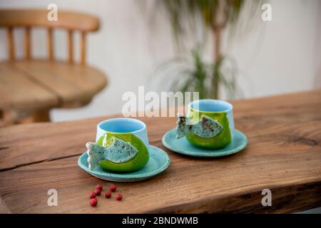 tasses en céramique faites main colorées sur une table en bois Banque D'Images