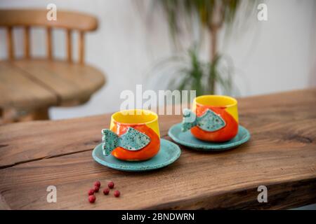 tasses en céramique faites main colorées sur une table en bois Banque D'Images
