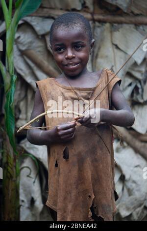 Baka enfant jouant avec Bow et Arrow, Sud-est Cameroun, juillet 2008. Banque D'Images